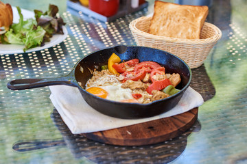 Delicious, hot sunny side up fried egg with bread and fresh vegetables.