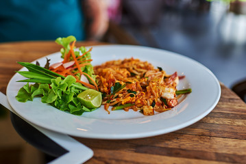 Vegetarian Thai  food, stir-fried rice noodles, on wooden background