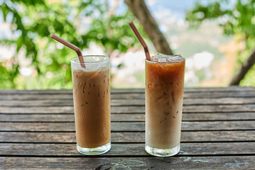 Two glass of ice coffee on old wooden table.