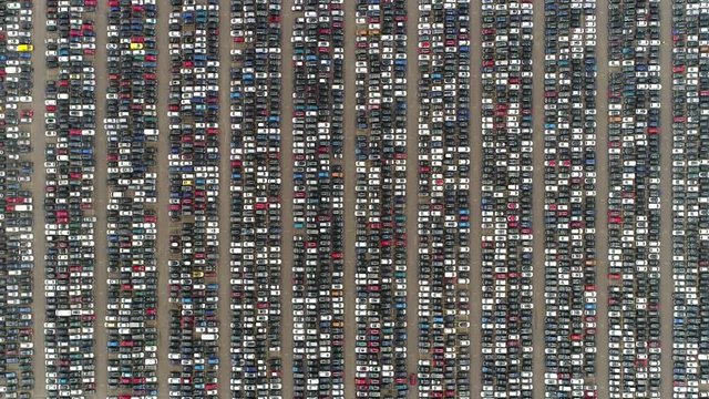 Aerial top down view of automaker car lot showing vehicles parked close to each other ready for further distribution the automotive industry is one of worlds most important economic sectors by revenue