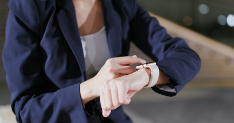 Obraz na płótnie Canvas Businesswoman use of smart watch at night