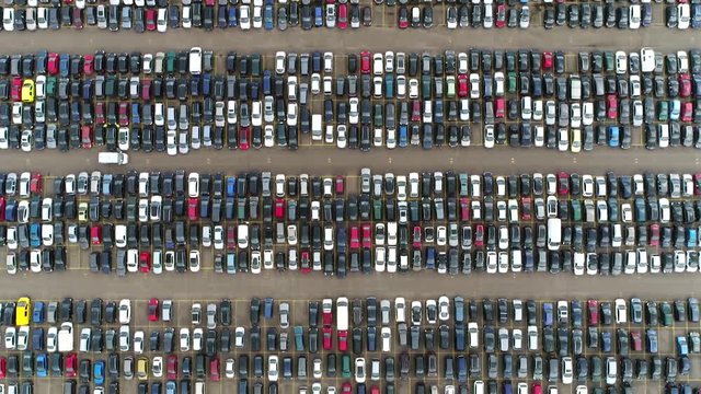 Aerial top down footage automaker car lot showing vehicles parked close to each other ready for further distribution the automotive industry is one of worlds most important economic sectors by revenue