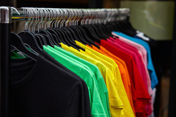 Colorful t-shirt for the man on hangers in a retail shop