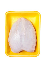Raw and uncooked chicken breast with skin in a yellow plastic container. Meat of poultry in tray, isolated on white background. Top view
