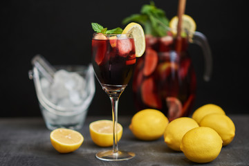 Red drink with ice. Cocktail with strawberries, orange, ice  and mint leaves. Summer cocktail sangria with fruit. Selective focus.