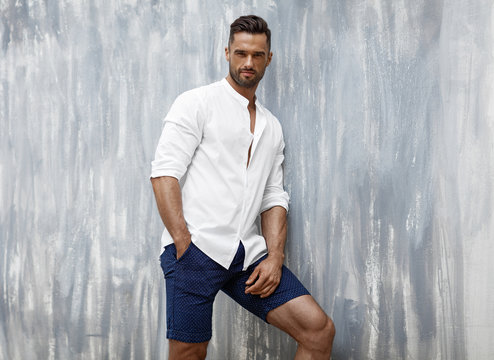 Handsome man in white shirt and shorts posing