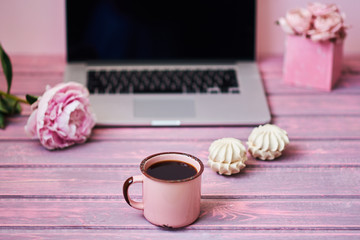 Open laptop  on a vintage wooden table. Portable net-book and cup of hot drink, electronic distance work via internet during coffee break. Feminine workplace. Vintage style. Selective focus.
