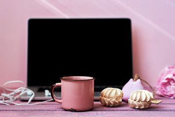 Open laptop  on a vintage wooden table. Portable net-book and cup of hot drink, electronic distance work via internet during coffee break. Feminine workplace. Vintage style. Selective focus.