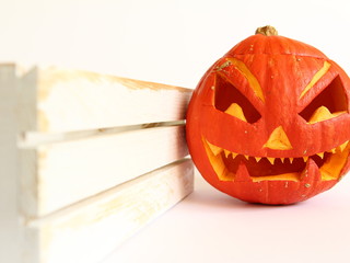 Przerażająca dynia na halloween z wyciętą twarzą z białą skrzynią - lampion ozdobny do wnętrz
