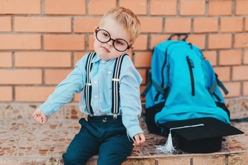 Happy smart kid in glasses is going to school for the first time. Child boy with bag go to elementary school. Child of primary school