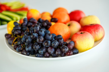 Naklejka na ściany i meble grapes and apples on a white plate