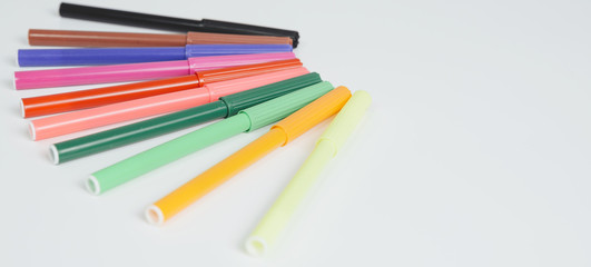 Different colored markers. Mazapples in various colors arranged in a semicircle. Concept of homework, return to school. Supplying school equipment.