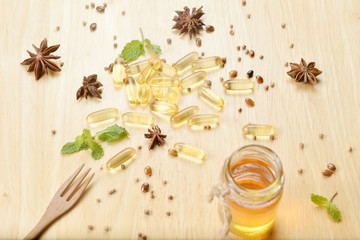 Fish oil on bottle with fork on brown wooden background with  many fish oils.