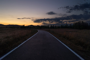 Strada tra i campi al tramonto, Italia