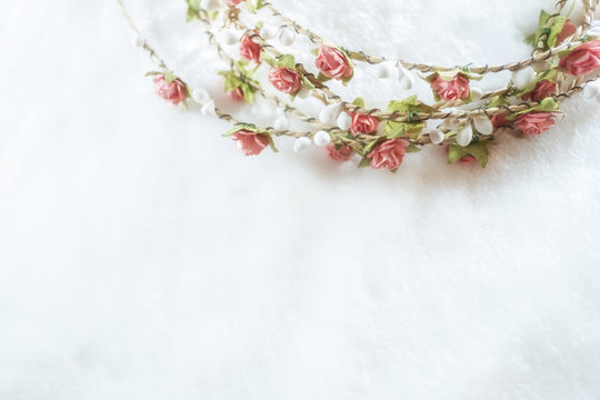 soft focus handmade floral tiara made of rose flowers on white fur background with copy space. hand crafted decorative fashion accessories. artificial flowers crown.