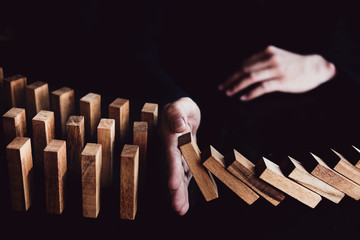 Business risk control concept, Businessman protect wooden block fall to planning and strategy in risk to business Alternative and prevent. Investment Insurance Business.