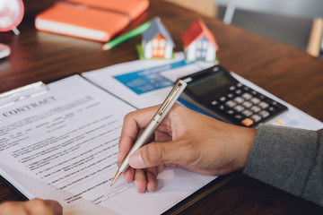 agreement to loan concept, client reading at contract loan document of banking and Study details before sign with pen.