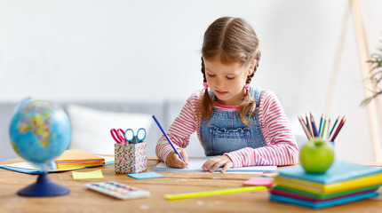 a child  girl  doing homework writing and reading at home

