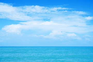 Fototapeta na wymiar Calm blue sea and white cloud in blue sky for nature and seascape background.