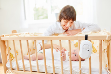 Fürsorgliche Mutter sitzt am Babybett