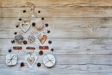 Creative Christmas tree, made up of gift box, gingerbread, Christmas decor and  Christmas spices on on dark wooden old background with a place for text.