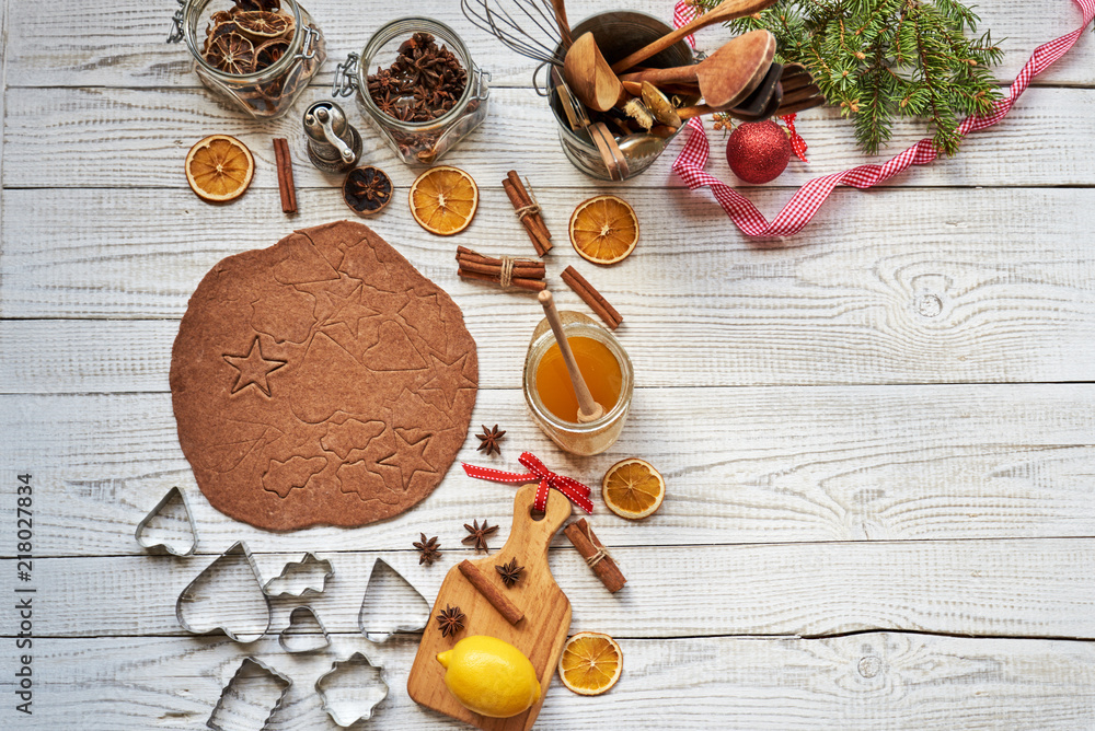 Wall mural Preparing gingerbread cookies for christmas.  Pastry cutters on wooden  board with festive decoration.