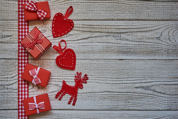 Christmas card with gift boxes, red heart and Christmas deer on  white wooden background. Christmas card with christmas natural decorations...