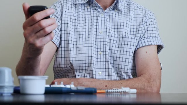 Man with diabetes perform the scan of the reader over the sensor