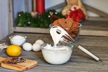 Bowl with icing,  whisk for whipping eggs, sugar, lemon and  gingerbread  on a old wooden table....