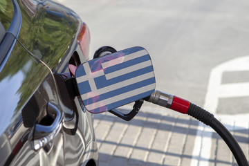 Fueling car with petrol pump at a gas station.
