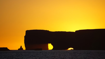 Sunset at Kirkjufjara beach and Dyrholaey rock at background at Vik, Iceland.  Black Sand Beach