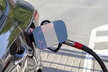 Fueling car with petrol pump at a gas station.