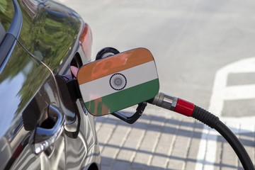 Fueling car with petrol pump at a gas station.