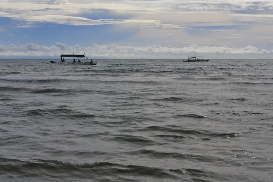 Local bangka boats in the open sea passing in front of Sugar Beach in barangay Nauhang at the beginning of sunset going in a south-north direction. Sipalay-Negros Occidental-West Visayas-Philippines.