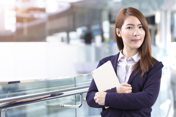 Business woman holding tablet in city with copy space