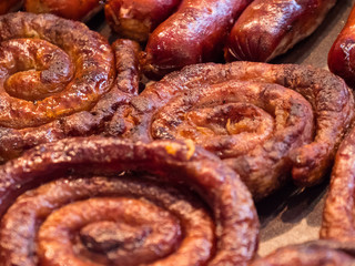 Grilling sausages on barbecue grill. Snacks at the Oktoberfest. Closeup of sausage on the grill. Selective focus. Cook puts sausage roasted on the grill.