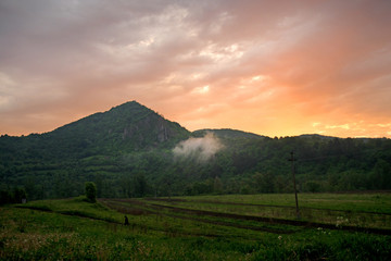 Small cloud formed from the early morning mountain dew evaporating on a hot day. Sun is rising...