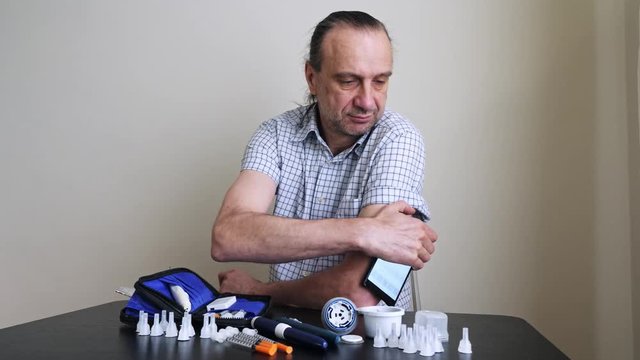 A man hands brings to the hand the smartphone for measuring glucose in the blood