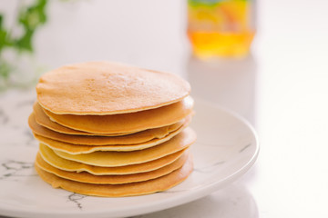 Stack of delicious pancakes on plate isolated on white