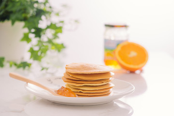 Stack of delicious pancakes on plate isolated on white