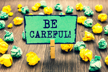 Text sign showing Be Careful. Conceptual photo making sure of avoiding potential danger mishap or harm Clothespin holding green note paper crumpled papers several tries mistakes.