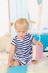 blond girl sitting on the floor with books