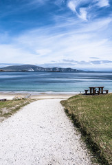 Path leading down to Keem Bay on Achill Island with picnic bench in the foreground and the Minaun Cliffs in the distance. Taken in summer