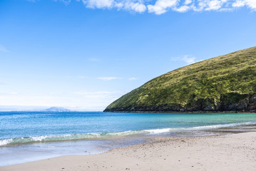 Fototapeta na wymiar View of the beautiful Keem Bay on Achill Island in Ireland. Sandy beach, calm ocean, tall cliffs and blue skies. Taken in summer.