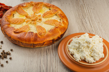 Home-made curd cake on a wooden background with ingredients.