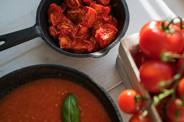 Traditional Italian cooking. Bowl of homemade sun dried tomatoes with olive oil and herbs on wooden background. Healthy food. Natural nutrition. Organic vegetables. Top view. Selective focus.