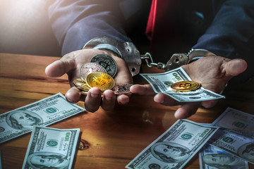 Businessman holding money and coin in hands with handcuff