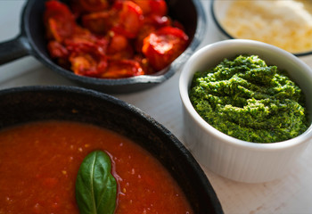 Bowl of homemade sun dried tomatoes with olive oil and herbs and fresh tomato sauce on wooden rustic table. Healthy food. Natural nutrition. Organic vegetables. Top view. Selective focus.