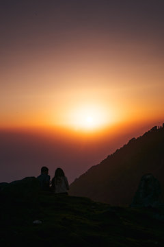 A couple who watching sunset on the mountain