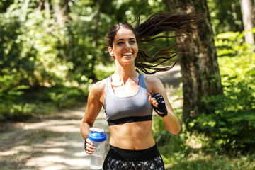 Young happy woman jogging outdoor at the park .